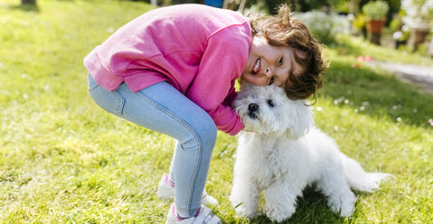 Kleines Mädchen mit ihrem Hund auf einer Wiese - MGOF001920