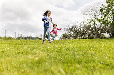 Two girls running on a meadow - MGOF001921