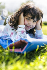 Portrait of smiling little girl lying on airbed on a meadow - MGOF001926