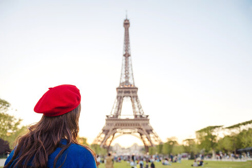 Frankreich, Paris, Champ de Mars, Rückenansicht einer Frau mit roter Baskenmütze mit Blick auf den Eiffelturm - GEMF000918