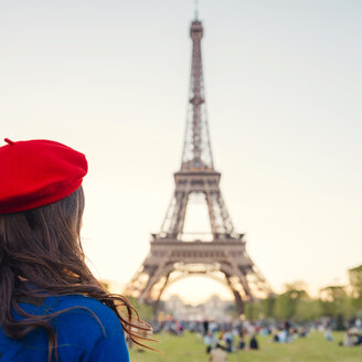 Frankreich, Paris, Champ de Mars, Rückenansicht einer Frau mit roter Baskenmütze mit Blick auf den Eiffelturm - GEMF000919