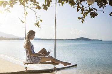 Thailand, Frau benutzt Laptop am Strand - SBOF000001