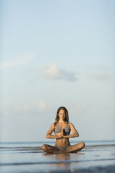 Thailand, Frau meditiert am Strand - SBOF000016