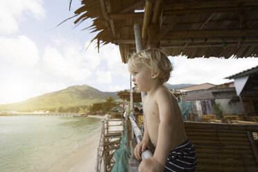 Thailand, Kleinkind in einer Hütte am Strand, das in die Ferne schaut - SBOF000029