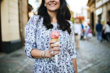 Woman holding strawberry ice cream cone - KIJF000411