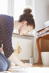 Young woman drawing pattern on the floor at home - SEGF000574