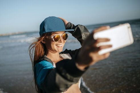 Junge Frau macht ein Selfie am Strand - KIJF000424