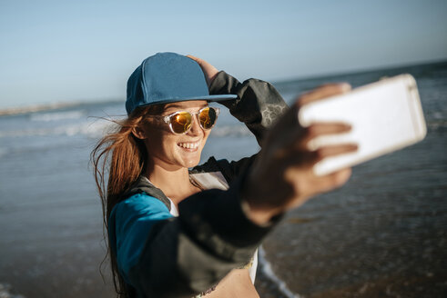 Young woman taking a selfie on the beach - KIJF000424