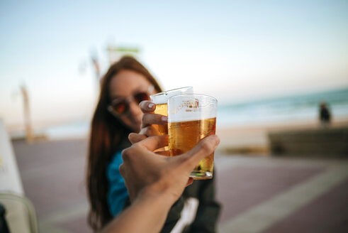 Clinking beer glasses by the sea - KIJF000434