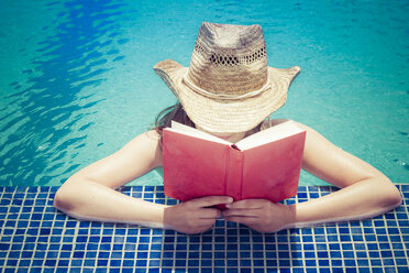 Frau mit Strohhut, die am Beckenrand ein Buch liest - CMF000479