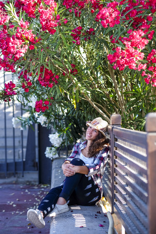 Junge Frau sitzt auf einer Bank und träumt, lizenzfreies Stockfoto
