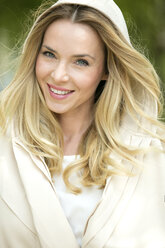 Portrait of smiling blond woman wearing hooded jacket - GDF001008