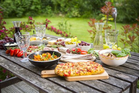 Auswahl an mediterranen Antipasti auf dem Gartentisch, lizenzfreies Stockfoto