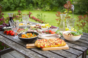 Auswahl an mediterranen Antipasti auf dem Gartentisch - SARF002760