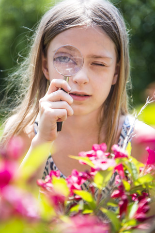 Porträt eines Mädchens, das durch ein Vergrößerungsglas schaut, lizenzfreies Stockfoto