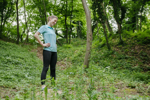 Lächelnde Sportlerin beim Ausruhen im Wald - ZEDF000197