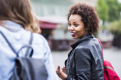 Portrait of astonished young woman looking at her friend stock photo