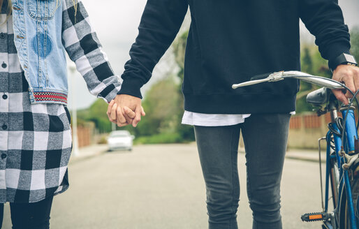 Couple with bicycle holding hands on the street - DAPF000119