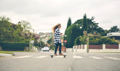 Junge Frau, die auf der Straße Skateboard fährt - DAPF000126