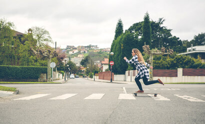 Junge Frau, die auf der Straße Skateboard fährt - DAPF000127