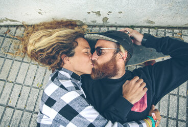 Couple lying on skateboard kissing - DAPF000140