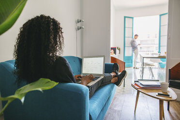 Young businesswoman working relaxed on couch - EBSF001442