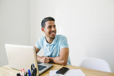 Young man working in office, using laptop - EBSF001493