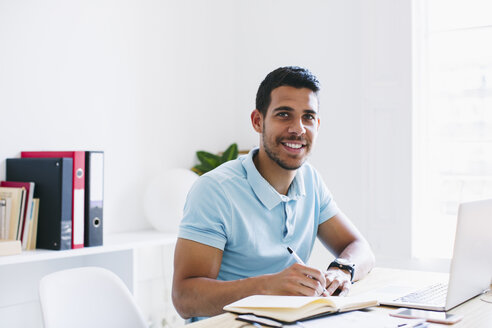 Young man working in office, using laptop - EBSF001510