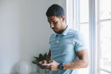 Junger Geschäftsmann im Büro mit digitalem Tablet - EBSF001511