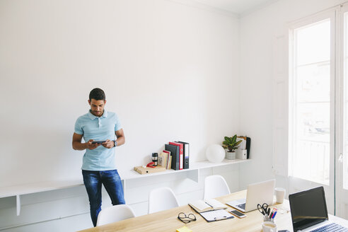 Junger Geschäftsmann im Büro mit digitalem Tablet - EBSF001514