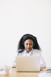 Young woman working in office, using laptop - EBSF001532