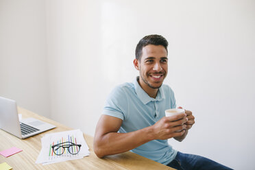 Young man in office drinking coffee - EBSF001538