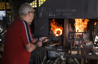 Man using a furnace in a glass factory in Mallorca - ABZF000667