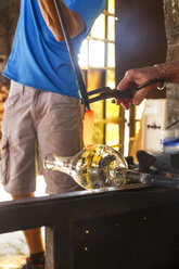 Männer bei der Arbeit mit geschmolzenem Glas in einer Glasfabrik - ABZF000668
