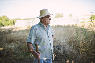 Portrait of a farmer with hatchet looking at distance - RAEF001218