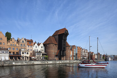 Poland, Gdansk, Motlawa bank with crane gate and sailing boat on Motlawa River - ABOF000089