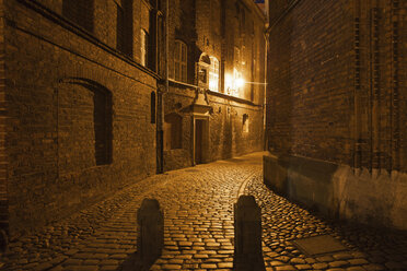 Poland, Gdansk, paved dark alley in historic city centre by night - ABOF000091