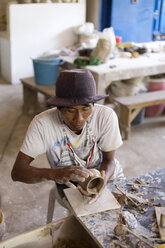 Potter in workshop working on earthenware jar - KNTF000372