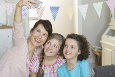 Glückliche Mutter und Töchter machen ein Selfie - NHF001493