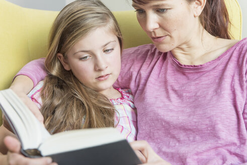 Mutter und Tochter lesen gemeinsam ein Buch - NHF001510