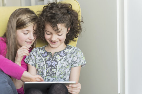 Zwei Mädchen benutzen ein digitales Tablet - NHF001514
