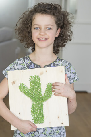 Mädchen hält Nagelbild mit Kaktus, lizenzfreies Stockfoto
