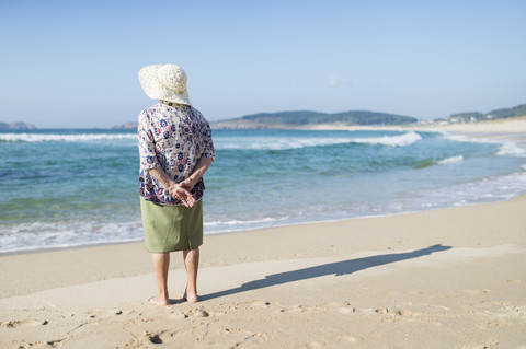 Rückenansicht einer älteren Frau am Strand, lizenzfreies Stockfoto