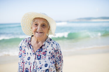 Portrait of smiling senior woman standing on the beach - RAEF001224