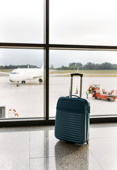 Koffer auf dem Flughafen, Passagierflugzeug und Gepäckwagen im Hintergrund - MGOF001950