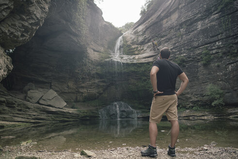 Spanien, Katalonien, Girona, Mann steht am Wasserfall La Roca Foradada - SKCF000092