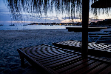 Mallorca, Strohsonnenschirme und Liegestühle am Strand bei Sonnenuntergang - ABZF000693