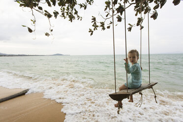 Young girl on beach, sitting on swing in Thailand - SBOF000047