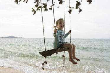 Young girl on beach, sitting on swing in Thailand - SBOF000048