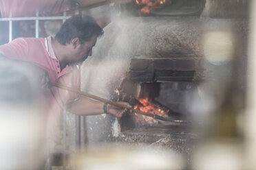 Pizzabäcker legt Pizza in den Pizzaofen - ZEF008719